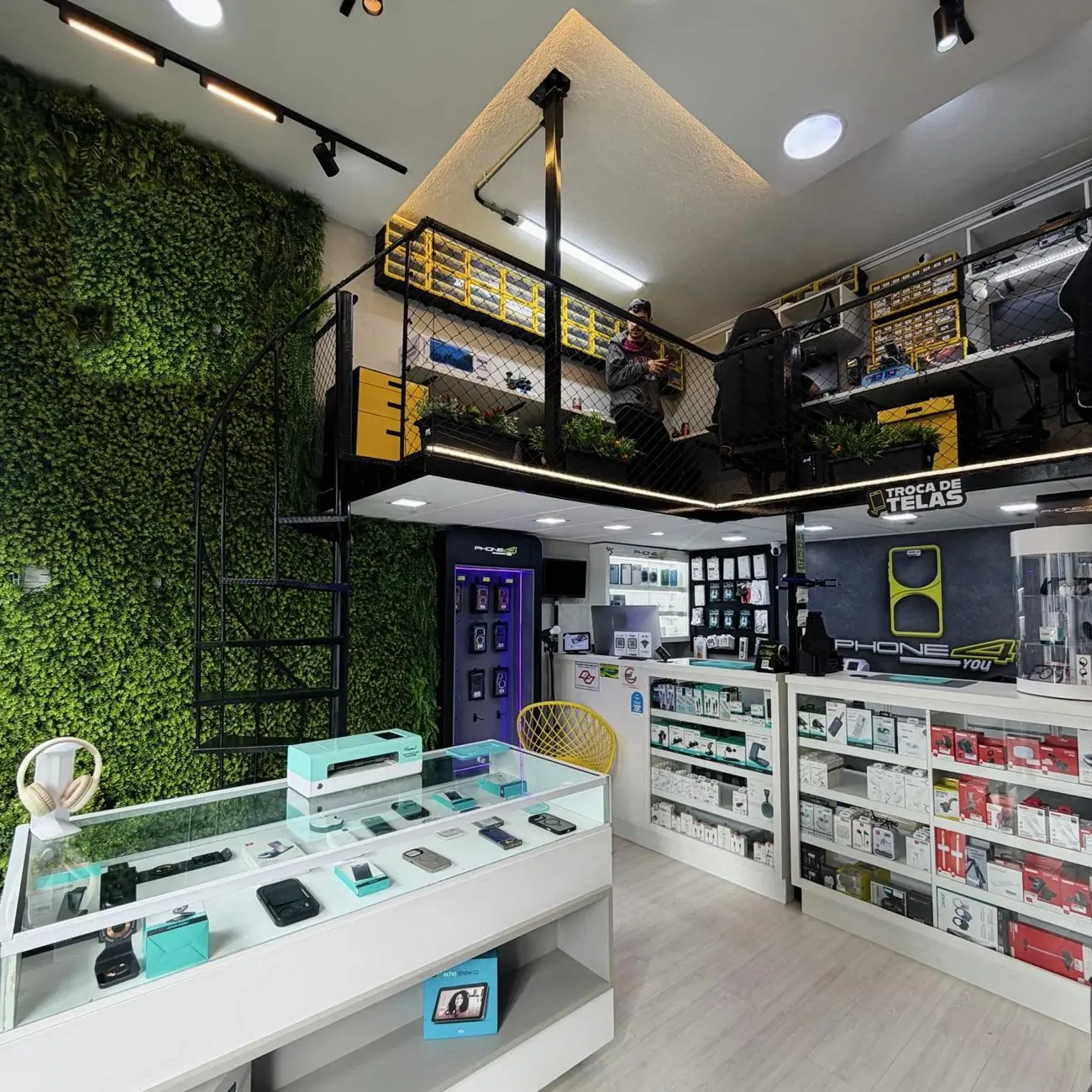 Interior da loja PHONE4YOU com parede verde e mezanino